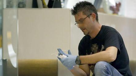 Ein Beamter bei der Untersuchung im Eingang des Silken Hotel in Barcelona. Hier hat ein Mann auf einen Belgier und einen Briten geschossen. 