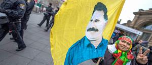 Eine Kurdin trägt in Frankfurt am Main eine Fahne mit dem Konterfei des PKK-Gründers Abdullah Öcalan.