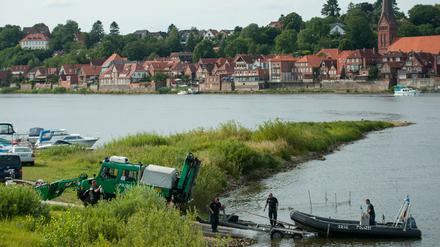 Ein Einsatzfahrzeug die Polizei zieht am 01.08.2015 bei Hohnstorf/Elbe (Niedersachsen) am Elbufer ein Polizeiboot aus dem Wasser. Nach dem Fund der Leiche des Familienvaters sucht die Polizei weiter nach der ebenfalls vermissten Mutter und Tochter.