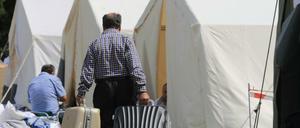 Asylsuchende treffen mit Koffern in der Zeltstadt der Zentralen Anlaufstelle für Asylbewerber in Halberstadt (Sachsen-Anhalt) ein. Mit dem Aufbau einer provisorischen Zeltstadt auf dem Gelände der Einrichtung soll die Kapazität zur Aufnahme für Zuflucht suchende Menschen aus Kriegs- und Krisenregionen deutlich erhöht werden.