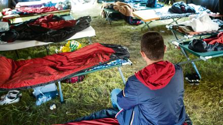 Ein 31 Jahre alter Asylbewerber aus Albanien, der nicht erkannt werden möchte, sitzt auf einer Liege in einem Gruppenzelt in der Zentralen Erstaufnahmestelle Brandenburgs in Eisenhüttenstadt.