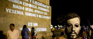 Der Fotograf Ruben Espinosa wird am Montag in Mexiko City beerdigt. Teilnehmer tragen Masken mit dem Bild des ermordeten Journalisten.
