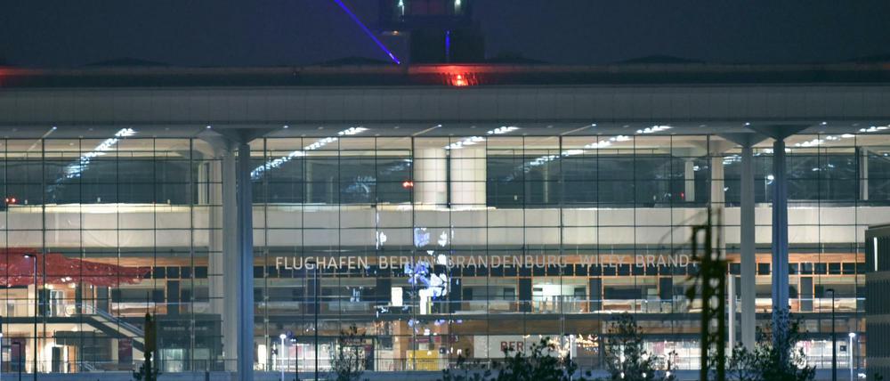 Abends ist das Hauptterminal des Hauptstadtflughafens BER beleuchtet. Die Arbeiten am Flughafen durch die Firma Imtech sollen trotz ihrer Insolvenz weitergehen.