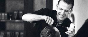 Naser Kassem zupft bei einem Kunden die Augenbrauen raus.