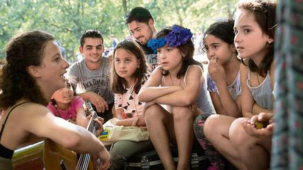 Ein bisschen Frieden. Eine Ehrenamtliche spielt für Flüchtlingskinder vor der zentralen Aufnahmestelle am Lageso.