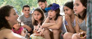 Ein bisschen Frieden. Eine Ehrenamtliche spielt für Flüchtlingskinder vor der zentralen Aufnahmestelle am Lageso. 