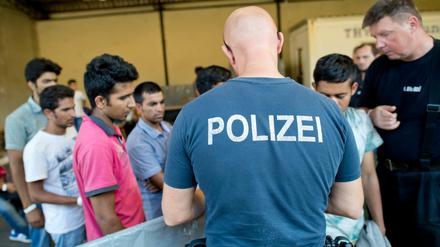 Flüchtlinge aus Afghanistan, Syrien und dem Irak werden am 10.08.2015 in der Registrierungsstelle für Flüchtlinge in Passau (Bayern) in Busse verteilt. Der anhaltend große Andrang von Flüchtlingen hat bei der Bundespolizei in Passau für zum Teil untragbare Zustände gesorgt. 