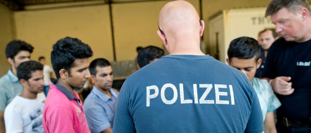 Flüchtlinge aus Afghanistan, Syrien und dem Irak werden am 10.08.2015 in der Registrierungsstelle für Flüchtlinge in Passau (Bayern) in Busse verteilt. Der anhaltend große Andrang von Flüchtlingen hat bei der Bundespolizei in Passau für zum Teil untragbare Zustände gesorgt.