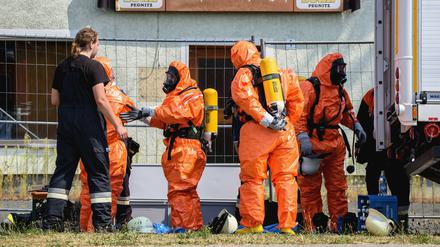 Einsatzkräfte der Feuerwehr ziehen sich am Dienstag in Engelmannsreuth (Bayern) Ganzkörper-Schutzanzüge an. Bei Engelmannsreuth ist ein F-16 Kampfjet der US-Streitkräfte abgestürzt.
