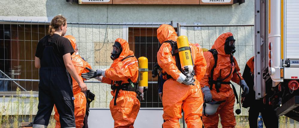 Einsatzkräfte der Feuerwehr ziehen sich am Dienstag in Engelmannsreuth (Bayern) Ganzkörper-Schutzanzüge an. Bei Engelmannsreuth ist ein F-16 Kampfjet der US-Streitkräfte abgestürzt.