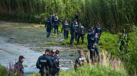 Polizisten durchsuchen am 05.08.2015 bei Winsen-Drage (Niedersachsen) das Elbufer. Nach dem Fund der Leiche des Familienvaters sucht die Polizei weiter nach der ebenfalls vermissten Mutter und Tochter. Knapp drei Wochen nach dem Verschwinden einer Familie in Drage sucht die Polizei nun auch mit Hilfe von «Aktenzeichen XY... ungelöst» nach Zeugen. 