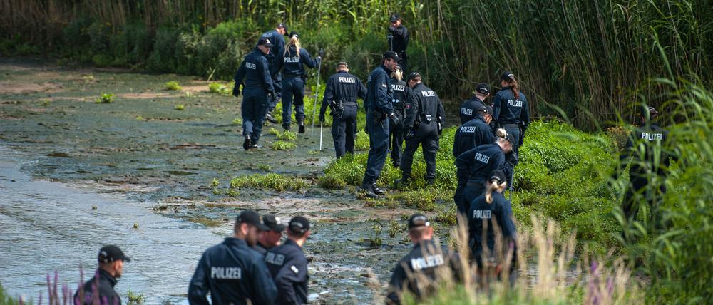 Polizisten durchsuchen am 05.08.2015 bei Winsen-Drage (Niedersachsen) das Elbufer. Nach dem Fund der Leiche des Familienvaters sucht die Polizei weiter nach der ebenfalls vermissten Mutter und Tochter. Knapp drei Wochen nach dem Verschwinden einer Familie in Drage sucht die Polizei nun auch mit Hilfe von «Aktenzeichen XY... ungelöst» nach Zeugen. 