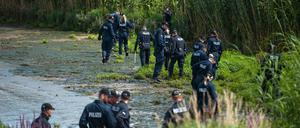 Polizisten durchsuchen am 05.08.2015 bei Winsen-Drage (Niedersachsen) das Elbufer. Nach dem Fund der Leiche des Familienvaters sucht die Polizei weiter nach der ebenfalls vermissten Mutter und Tochter. Knapp drei Wochen nach dem Verschwinden einer Familie in Drage sucht die Polizei nun auch mit Hilfe von «Aktenzeichen XY... ungelöst» nach Zeugen. 