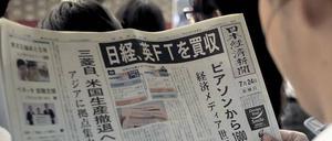 Aufregende Lektüre. Ein Mann in einem Tokioter Bahnhof liest in der „Nikkei“-Ausgabe vom 24. Juli den Aufmacher über den Kauf der britischen „Financial Times“.