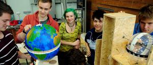 Studenten im MINT grün Programm basteln an einer Apparatur, in der ein Globus eingebaut ist.