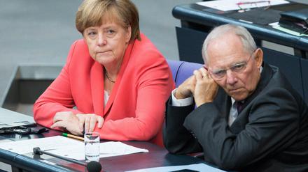 Bundeskanzlerin Angela Merkel (l, CDU) und Bundesfinanzminister Wolfgang Schäuble (CDU) unterhalten sich am 17.07.2015 während der Sondersitzung des Deutschen Bundestags zu Griechenland-Hilfspaketen in Berlin. 