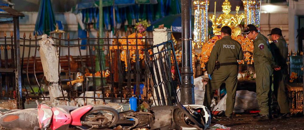 Nach der Bombenexplosion im Zentrum von Bangkok untersuchen Polizisten die Spuren.