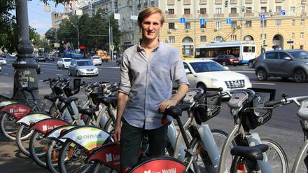 Wladimir Kumow, einer der Organisatoren der Fahrrad-Paraden in Moskau, posiert am 10.08.2015 vor einer Station für öffentliche Leihfahrräder in Moskau.