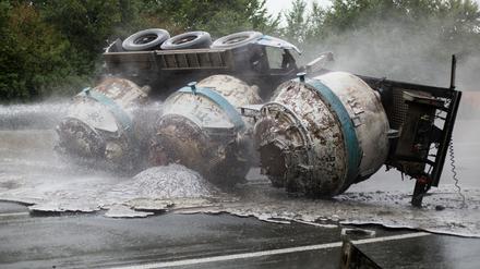 Feuerwehrleute löschen am 16.08.2015 in Schwerte (Nordrhein-Westfalen) einen Lastwagen. Bei einem Lastwagenunfall auf der A1 bei Schwerte hat am Sonntagmorgen flüssiges Aluminium Teile der Fahrbahn in Brand gesetzt. 