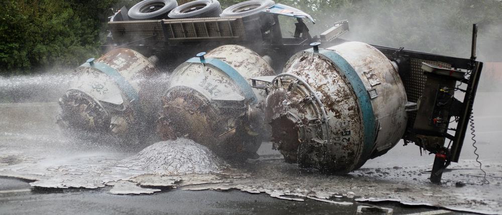 Feuerwehrleute löschen am 16.08.2015 in Schwerte (Nordrhein-Westfalen) einen Lastwagen. Bei einem Lastwagenunfall auf der A1 bei Schwerte hat am Sonntagmorgen flüssiges Aluminium Teile der Fahrbahn in Brand gesetzt. 