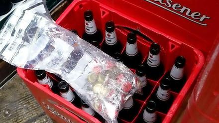 Einbruch in Getränkemarkt in Mülheim: Die Täter rührten das Bier nicht an. Sie hatten es auf die Kronkorken abgesehen. Das Bild der Polizei Essen zeigt die eingesammelten Nieten auf den geöffneten Flaschen. 