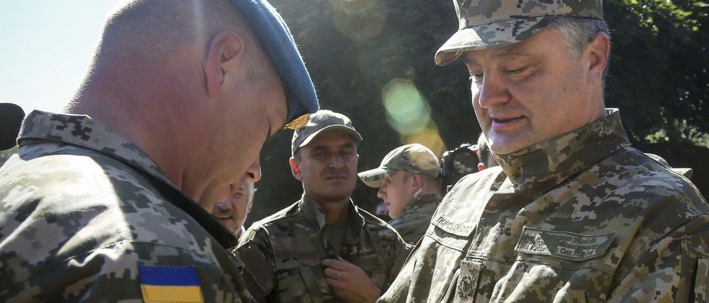 Der ukrainische Präsident Petro Poroschenko verleiht Medaillen an seine Soldaten. Wirtschaftlich geht es in der Ukraine aber nicht vorwärts.