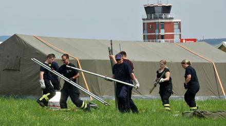 Helfer des Technischen Hilfswerks (THW) errichten am 24.07.2015 auf dem alten Flugplatz in Calden (Hessen) Zelte für Flüchtlinge. In der Stadt gibt es derzeit Probleme zwischen Einwohnern und Neuankömmlingen. 