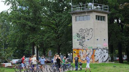Kiek an, hier stand die Mauer. Neugierige erkunden den Grenzstreifen, in diesem Fall müsste es der Wachturm sein am Schlesischen Busch zwischen Berlin-Kreuzberg und Berlin-Treptow.