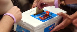Stimmzettel werden in einen Karton mit dem AfD-Logo gesteckt.