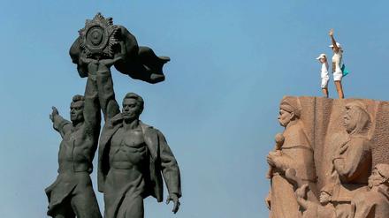 Zwei Besucher am Denkmal für die Freundschaft der Nationen in Kiew. 