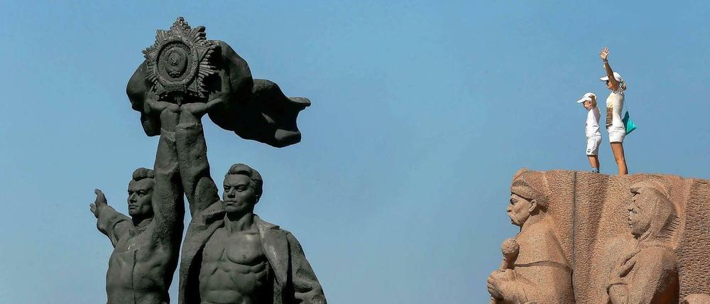 Zwei Besucher am Denkmal für die Freundschaft der Nationen in Kiew.