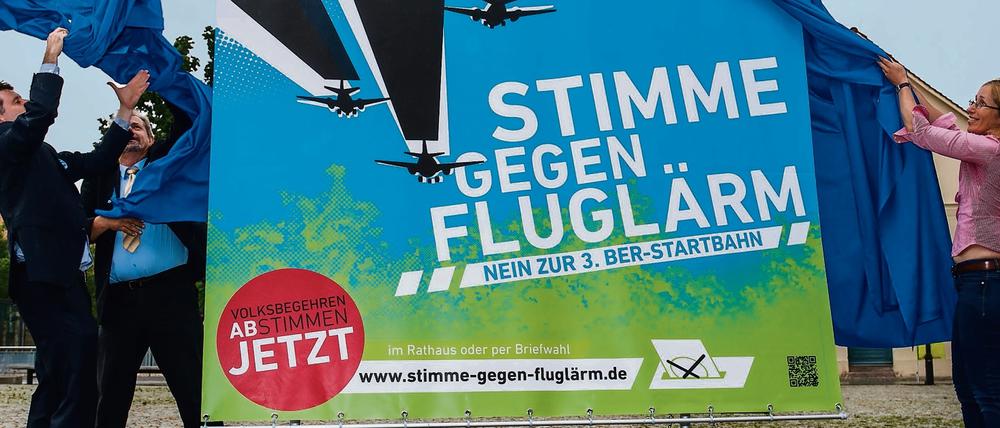 Dagegen, dagegen! Gegner enthüllen Plakat.