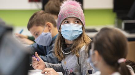 Mit Mundschutzmasken sitzen Schüler der fünften Klasse eines Gymnasiums  im Unterricht.