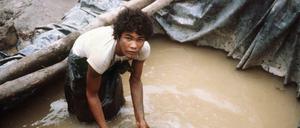 Ein Goldwäscher bei der Arbeit in der brasilianischen Goldmine Serra Pelada. Nur die wenigsten Menschen werden durch die Goldsuche in Südamerika reich. Der erfolgreiche Goldabbau erfordert Kapital, das nur große Firmen haben. Die Arbeit mit dem Schüttelsieb hingegen ist besonders zäh und letztlich auch Glückssache.