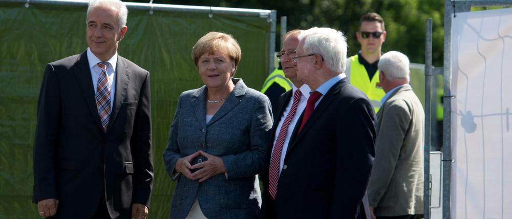 Bundeskanzlerin Angela Merkel (CDU) trifft an der Flüchtlingsunterkunft in Heidenau (Sachsen) ein und wird von dem DRK Präsidenten Rudolf Seiters (r), dem Ministerpräsidenten von Sachsen Stanislaw Tillich (CDU, l) und dem Bürgermeister von Heidenau Jürgen Opitz (3.v.l.) begrüßt.