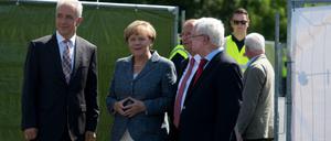 Bundeskanzlerin Angela Merkel (CDU) trifft an der Flüchtlingsunterkunft in Heidenau (Sachsen) ein und wird von dem DRK Präsidenten Rudolf Seiters (r), dem Ministerpräsidenten von Sachsen Stanislaw Tillich (CDU, l) und dem Bürgermeister von Heidenau Jürgen Opitz (3.v.l.) begrüßt.