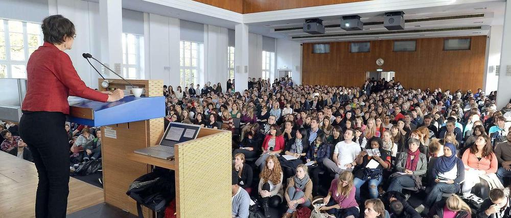 Eine Professorin spricht vor Studierenden im Hörsaal.