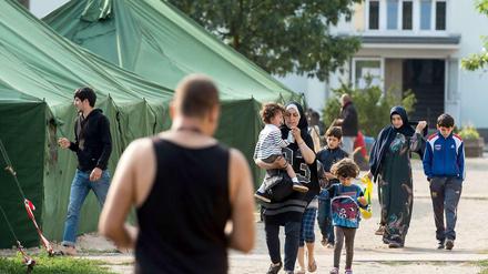 Gekommen, um zu bleiben. Flüchtlinge vor der Erstaufnahmestelle für Asylbewerber in Eisenhüttenstadt. 