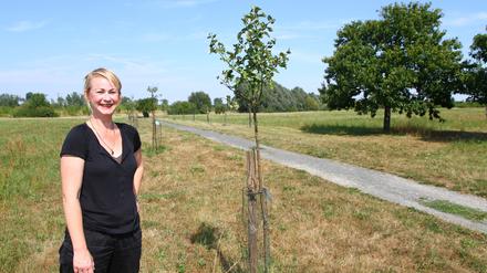 Cordelia Koch , Vorstandsmitglied von Bündnis 90/Die Grünen, zeigt frisch gepflanzte und pflegebedürftige Obstbäume.