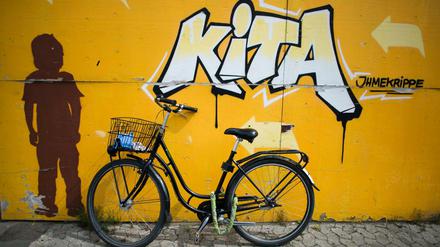Ein Fahrrad lehnt in Hannover an einer Wand. Was wären moderne Eltern ohne Kindergärten? Früher versorgten Großeltern die Kinder. Heute müssen Erwachsene häufig Kinder und Großeltern pflegen.
