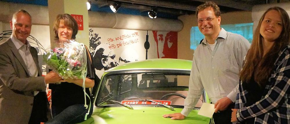 Blumengrüße am „Trabi“. Bernhard Schütte (li.) von der „Story of Berlin“ begrüßt eine Potsdamer Familie. Mit ihrem Besuch stieg die Gästezahl auf die Einwohnerzahl Berlins. 