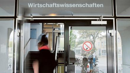 Ein Mann geht durch die Tür eines Uni-Gebäudes.