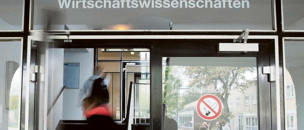 Ein Mann geht durch die Tür eines Uni-Gebäudes.