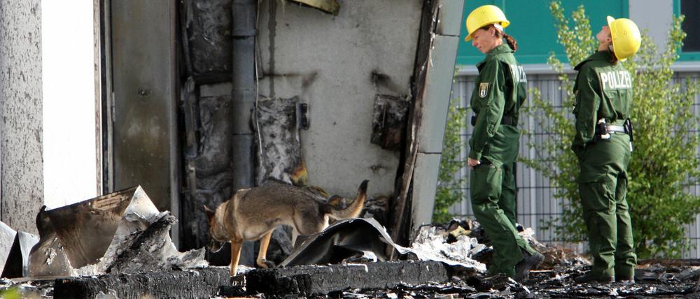 Spürhunde der Berliner Polizei sind in Nauen (Brandenburg) vor der abgebrannten Turnhalle im Einsatz. Ganz in der Nähe halten die Berliner Grünen ihre jährliche Fraktionsklausur ab.