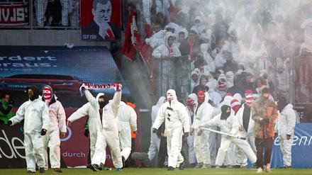 Kölner Fans stürmen den Rasen nach dem Spiel in Gladbach. Darunter müssen nun auch die Anhänger der Borussia leiden.