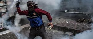 Ein kurdischer Demonstrant schleudert eine Gas-Kartusche auf türkische Polizisten. Die gewalttätigen Proteste schaden den Chancen der kurdischen HDP-Partei.
