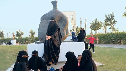Frauen picknicken im neuen Skulpturenpark am Roten Meer vor einer Plastik von Henry Moore.
