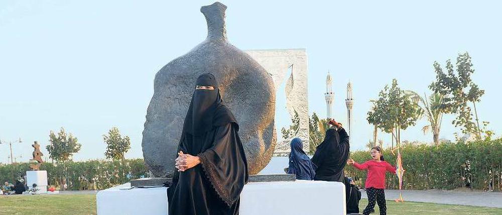 Frauen picknicken im neuen Skulpturenpark am Roten Meer vor einer Plastik von Henry Moore.