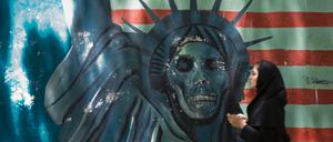 Eine Frau läuft in Teheran an einem Anti-USA-Graffiti vorbei.