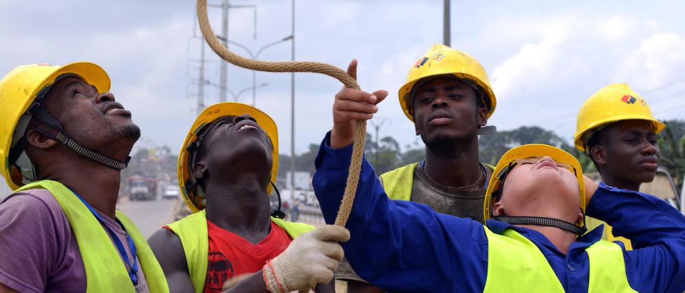 Das rohstoffhungrige China investierte viele Jahre lang kräftig in Afrika. Das ändert sich. Zudem macht der Ölpreis Probleme. Das Foto zeigt einen Mitarbeiter des Konzerns Power China mit Arbeitern an der Elfenbeinküste.